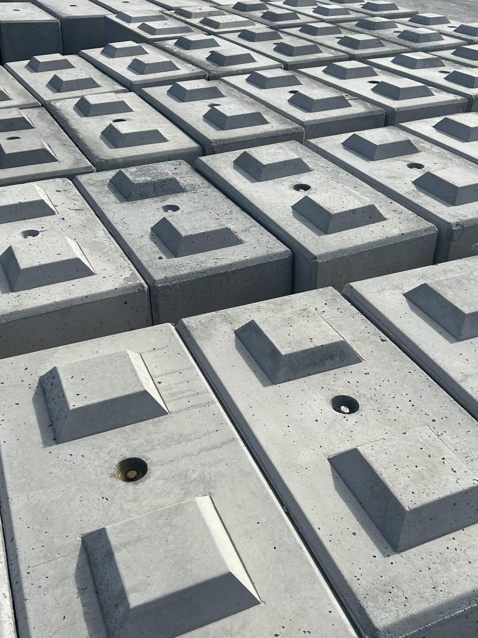 Precast concrete blocks neatly stacked at a storage yard ready for site preparation and installation.