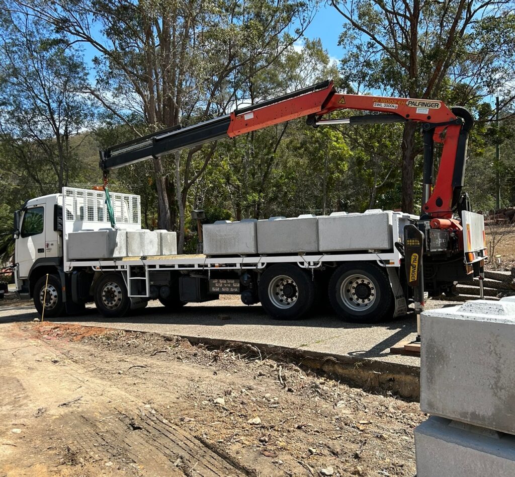 Recycled concrete blocks being delivered by a crane truck at a construction site