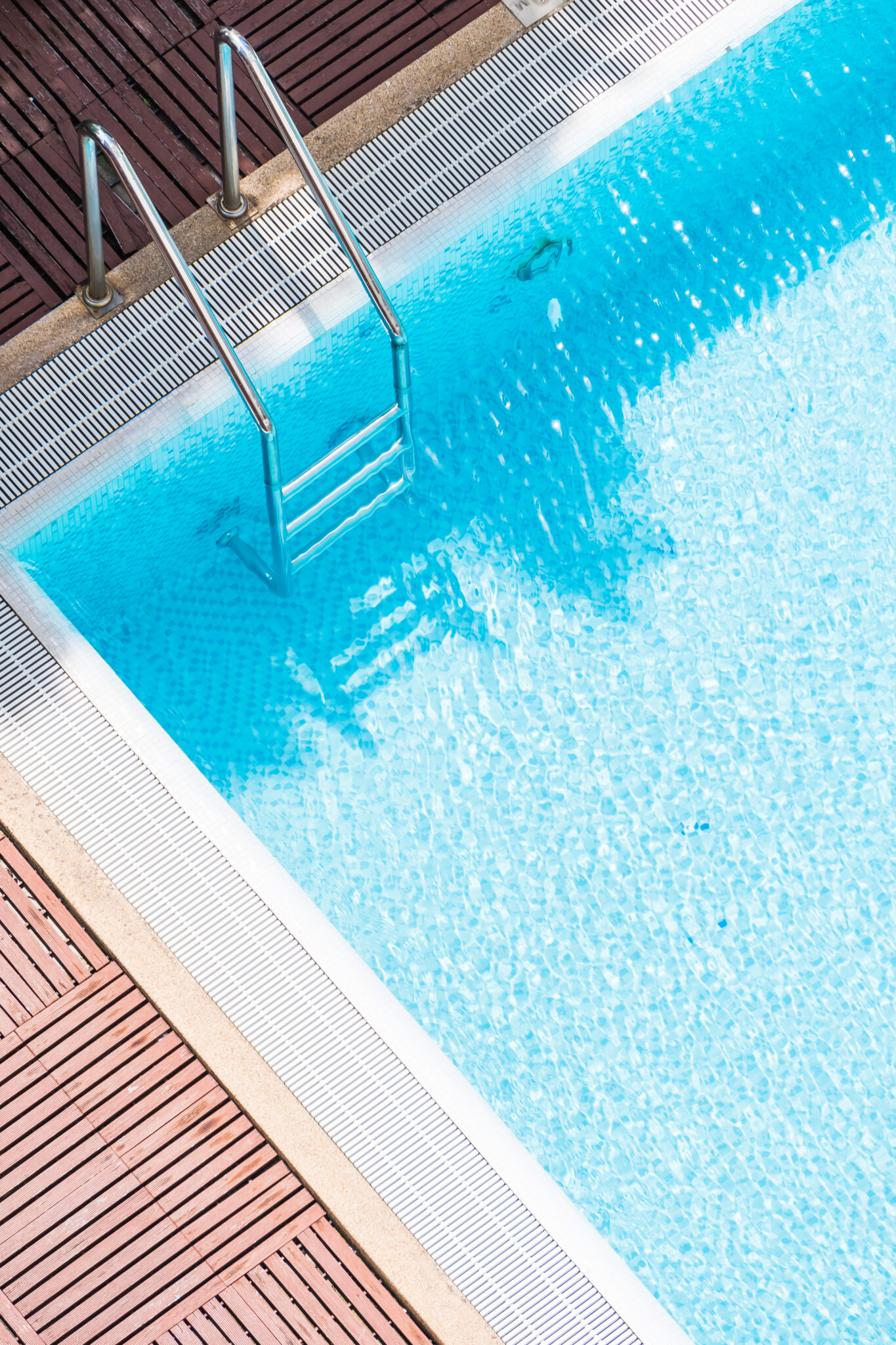 Swimming pool with a retaining wall and ladder, showcasing pool design with durable structural elements