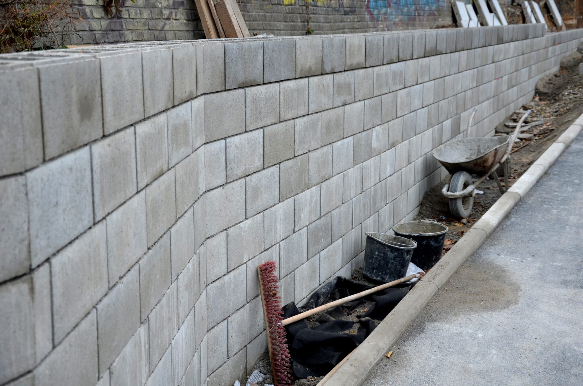 Concrete block retaining wall under construction highlighting why it’s smart to plan your retaining wall in winter