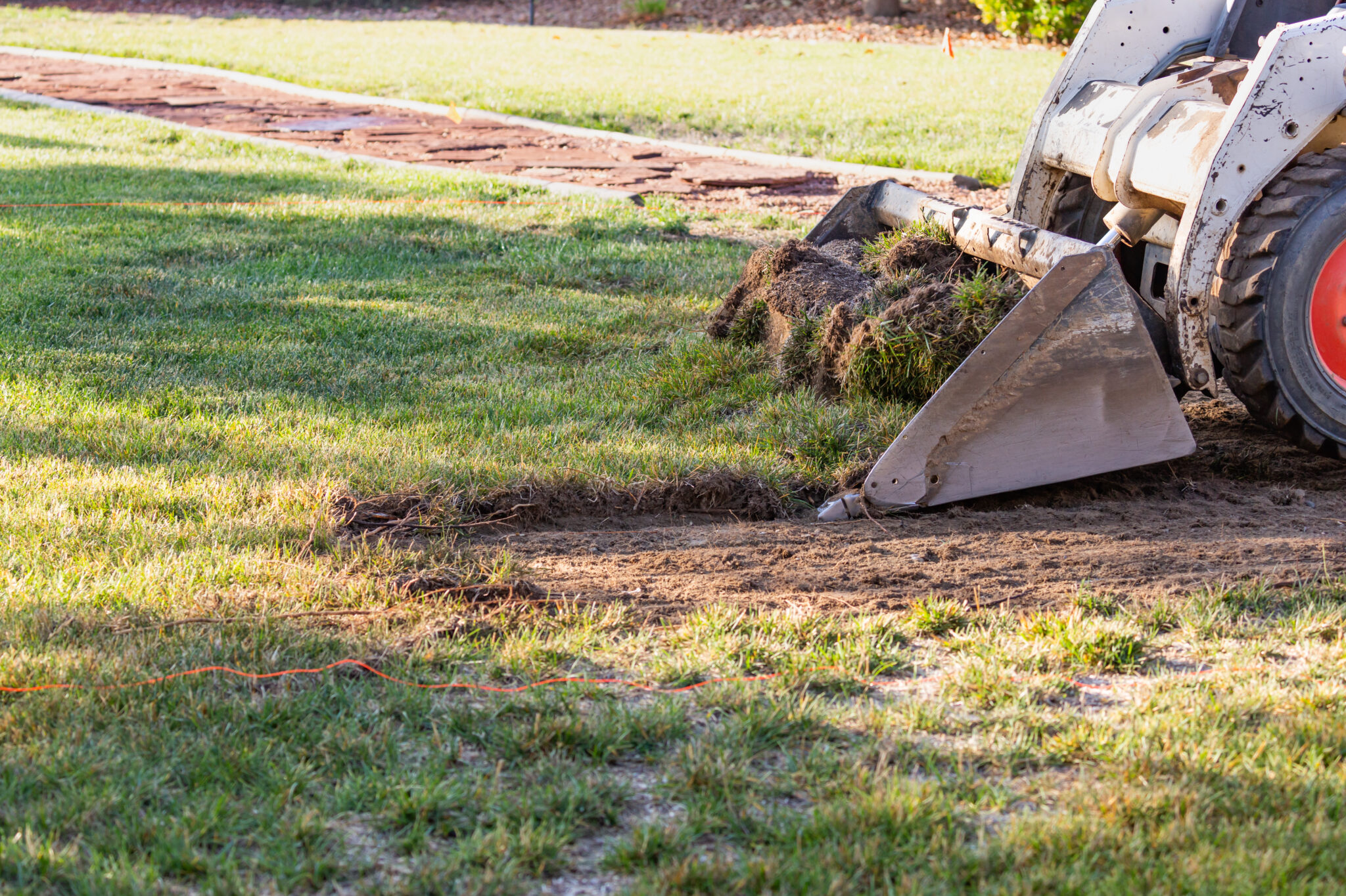 Excavator preparing ground to plan your retaining wall in winter with proper site preparation.