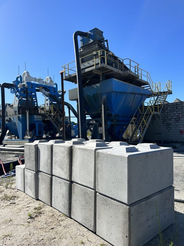 Precast concrete blocks on the Gold Coast beside heavy machinery, highlighting sustainable building material production.