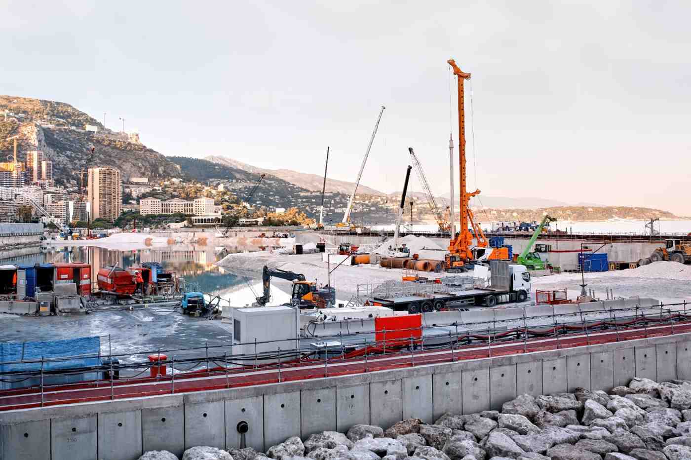 Harbour development site on the Gold Coast featuring cranes and heavy equipment using sustainable construction materials for marine infrastructure.