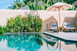 Resort-style pool area with lounge chairs and umbrella used in Gold Coast pool landscaping design.
