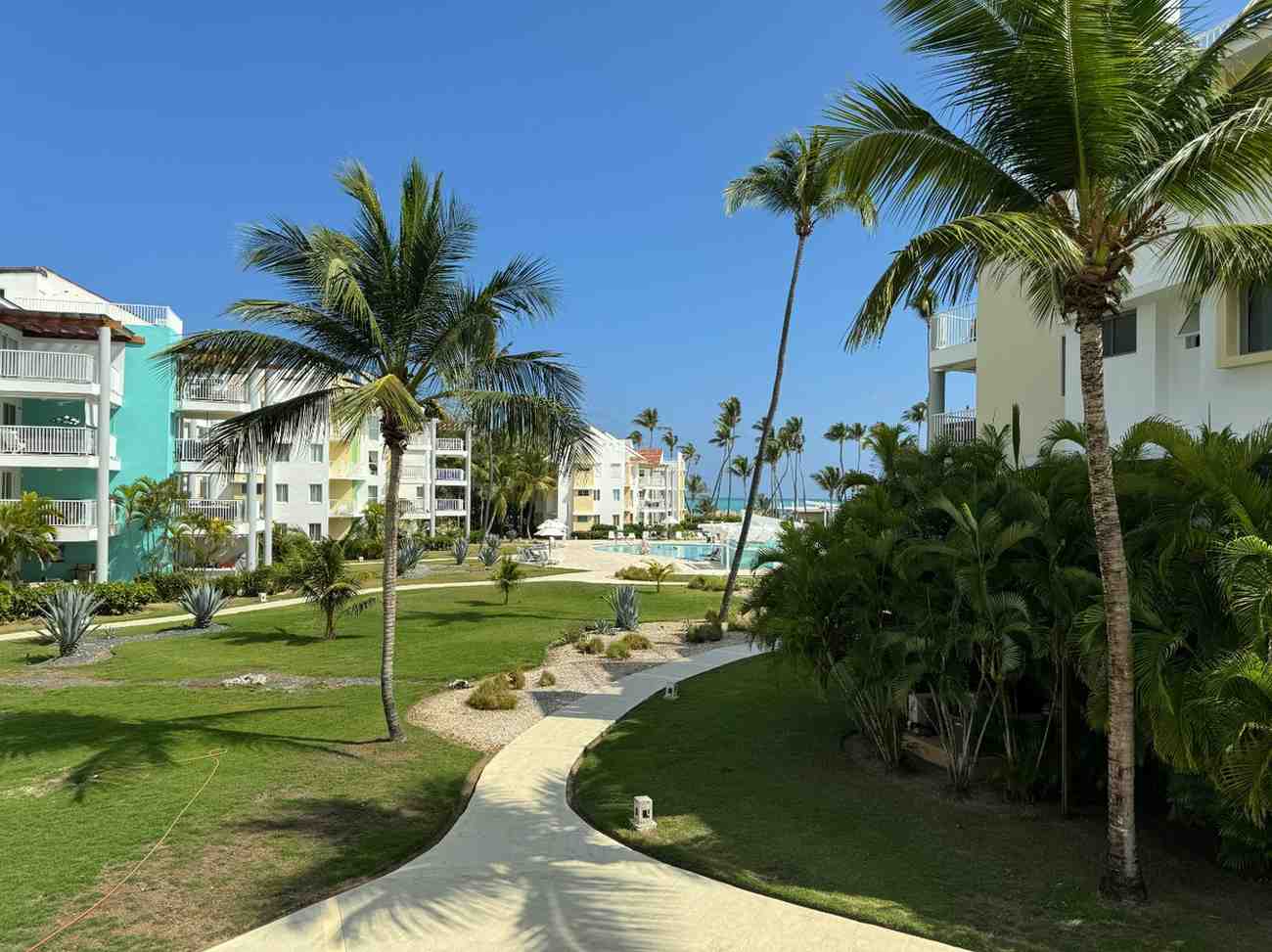 A modern beachfront apartment complex surrounded by palm trees, showcasing durable design ideal for precast concrete coastal homes.