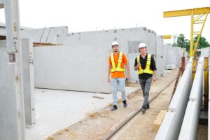 Engineers inspecting precast concrete blocks for summer builds at a modern construction facility.