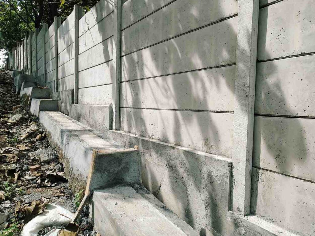Concrete sleeper retaining wall construction requiring council approval on a sloped property in the Gold Coast