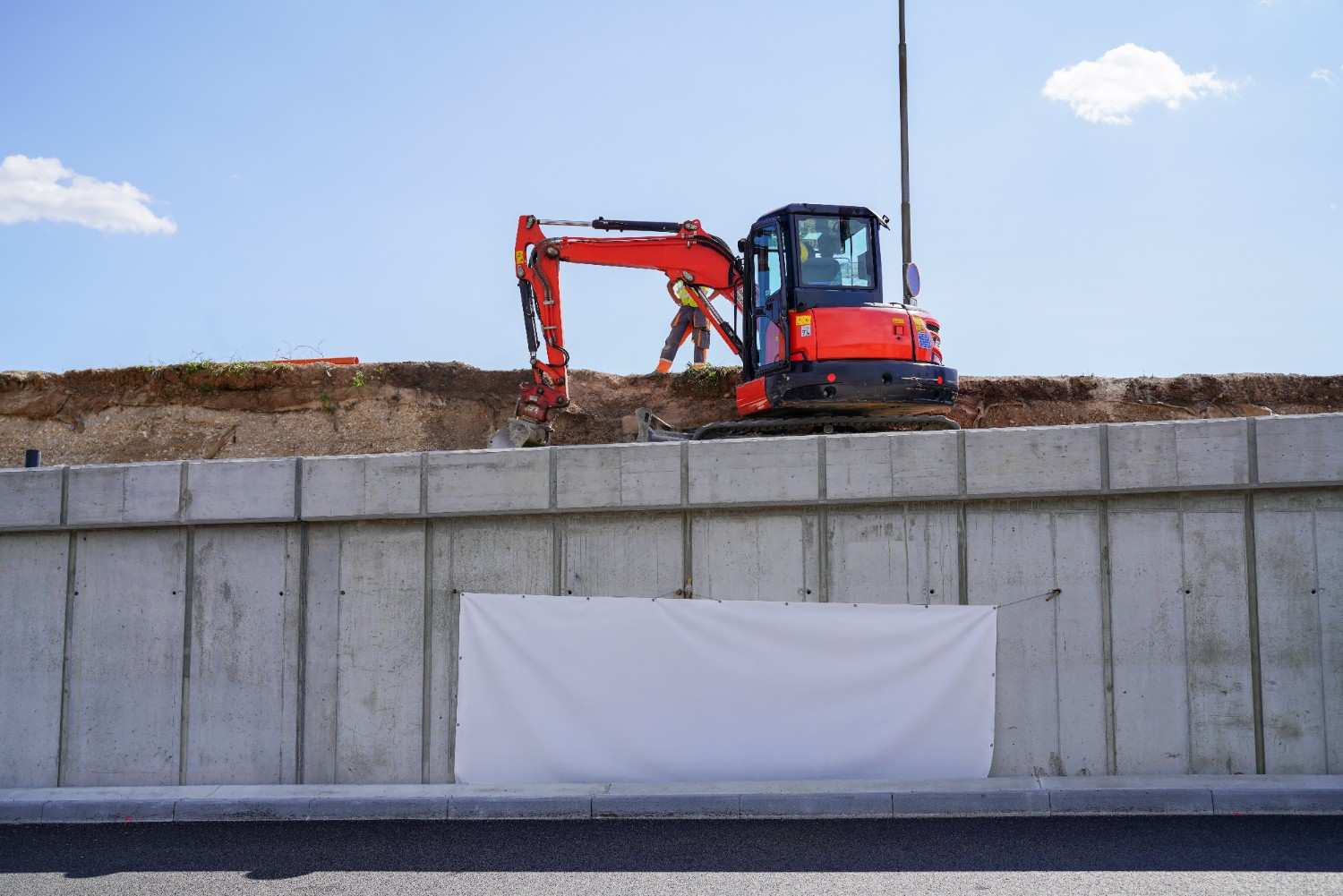 Wet season retaining wall prep with excavator completing retaining wall build before heavy rain