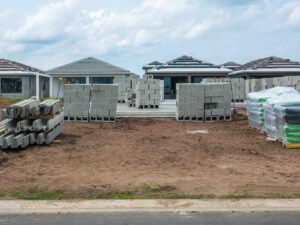 Precast vs poured concrete in wet conditions with stacked precast blocks at a residential construction site