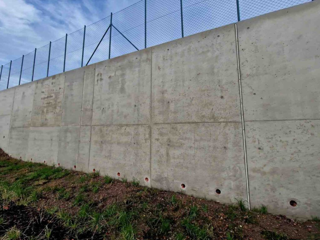 retaining wall failure signs showing drainage weep holes and moisture staining on a concrete retaining wall